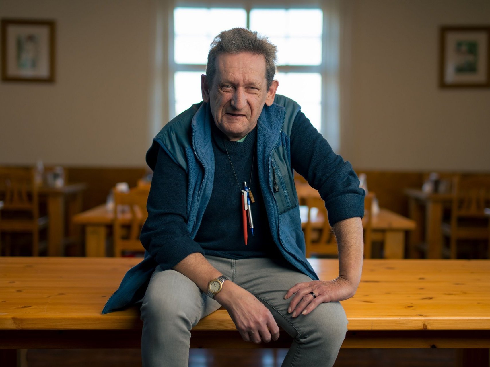 Ein Bewohnender sitzt auf einem Tisch und redet.