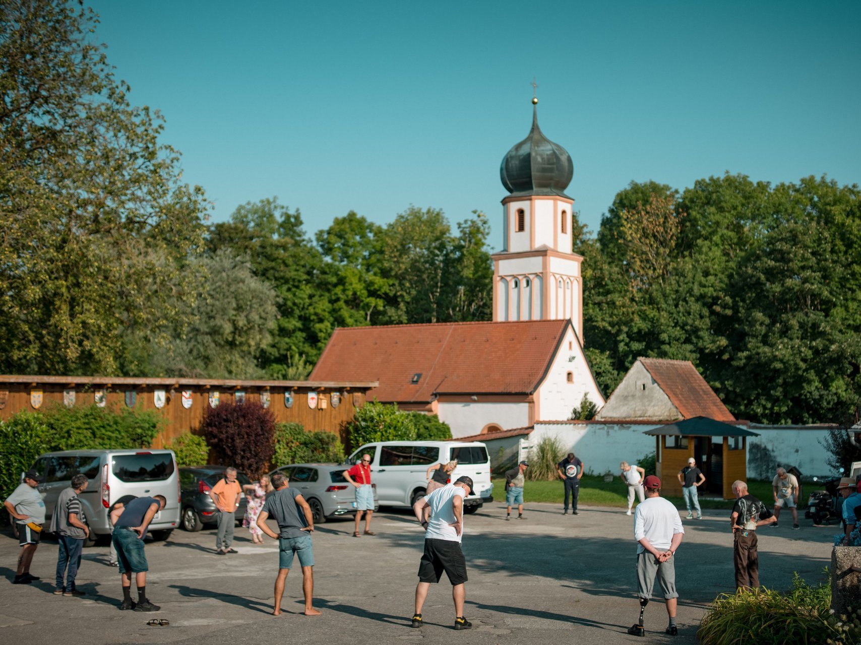 Frauen und Männer stehen vor der Einrichtung auf dem Hof in einem großen Kreis und dehnen sich gemeinsam.