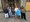 Sieben Personen posieren für ein Gruppenfoto vor der steinernen Fassade einer gotischen Kathedrale. Die Gruppe besteht aus Männern und Frauen in legere Freizeitkleidung, darunter Jacken, Mützen und Shorts.