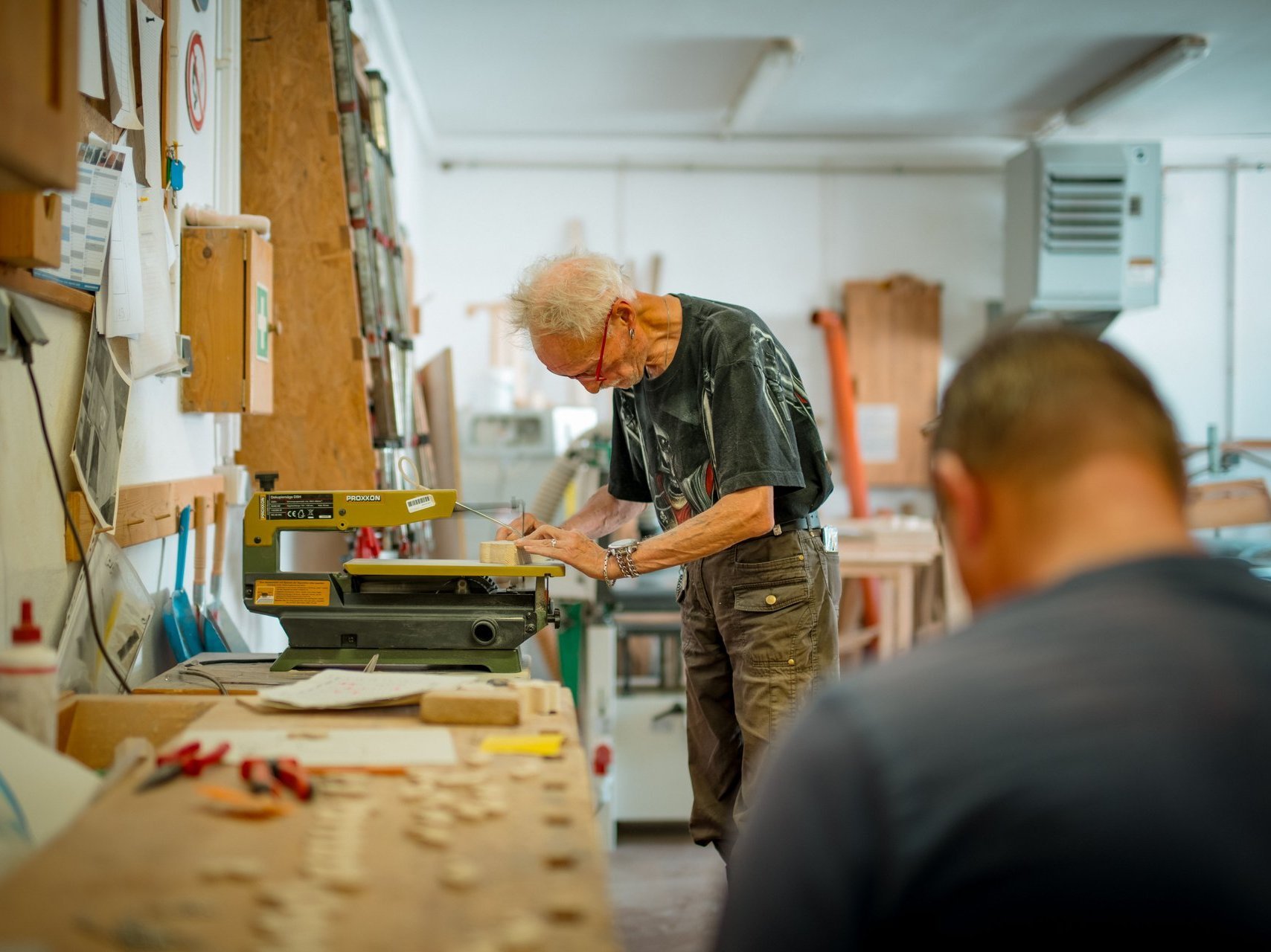 Die Bewohnenden arbeiten in einer Werkstatt gemeinsam an einem Projekt.
