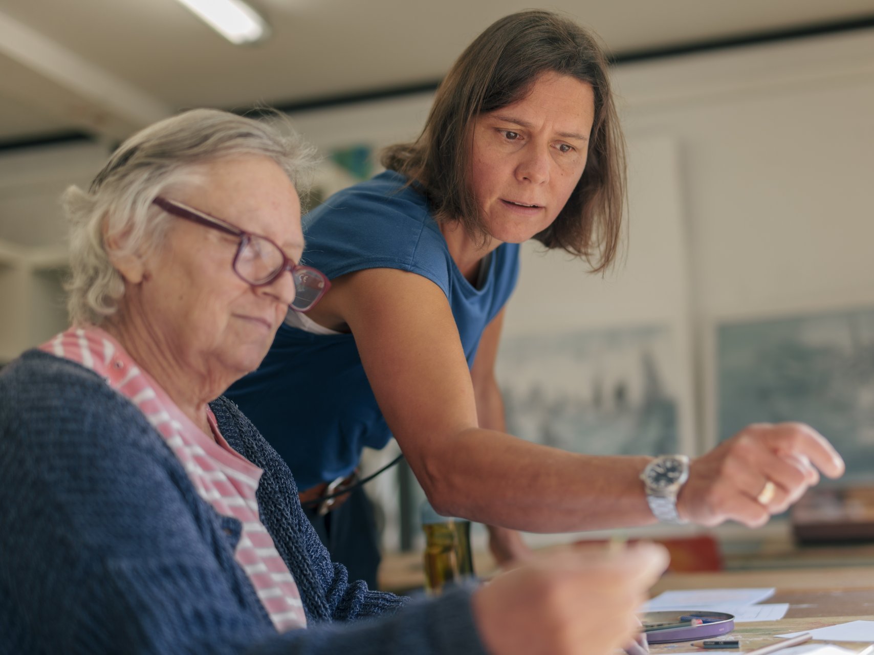 eine Frau zeigt einer anderen Frau etwas beim zeichnen