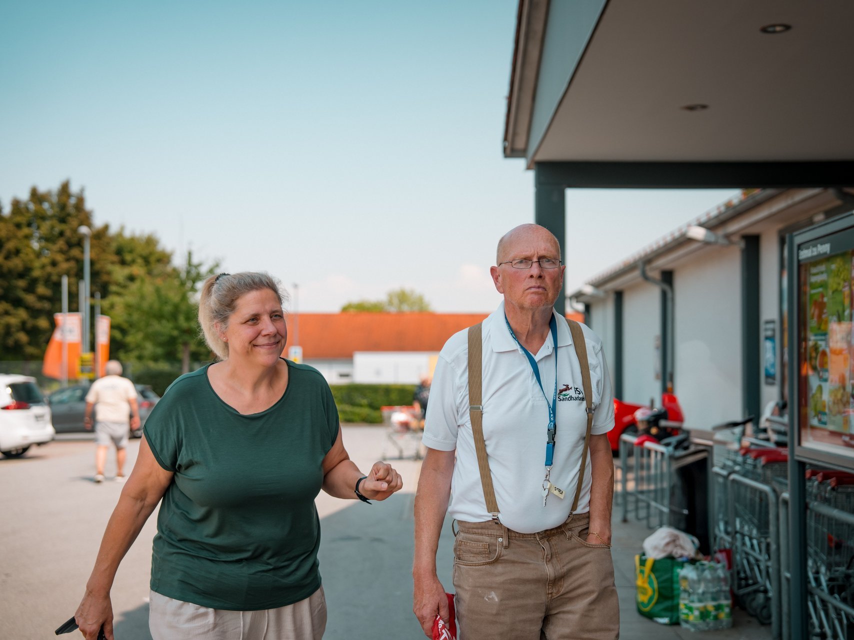 Eine Mitarbeitende und ein Bewohnender gehen in eine Supermarkt rein.