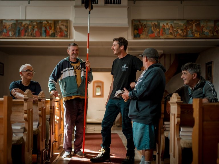 Eine Gruppe von Männern unterhält sich, während sie in der Kirche stehen.