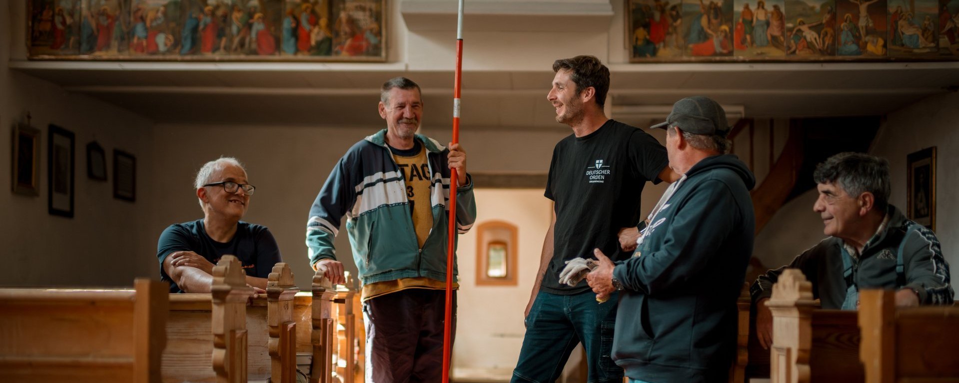 Eine Gruppe von Männern unterhält sich, während sie in der Kirche stehen.