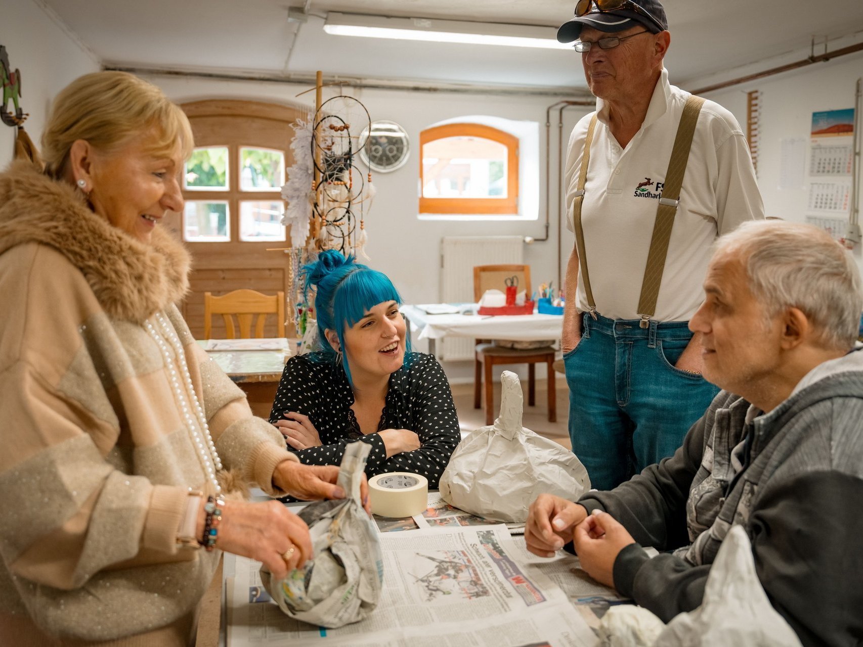 Bewohnende haben ihr Projekt aus Zeitung fertiggestellt und unterhalten sich darüber.